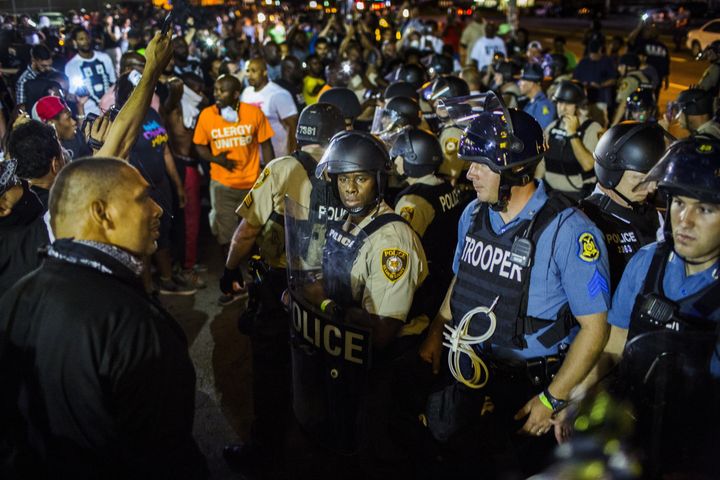 St Louis County police officers interact with anti-police demonstrators during protests in Ferguson, Missouri in August 2015.