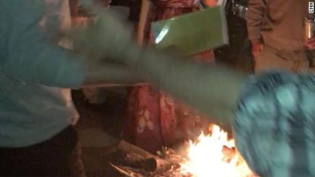 An image taken from video shows a book being thrown into a fire at the party.