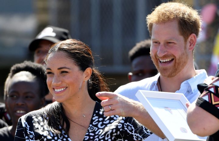 Prince Harry and his Meghan Markle smile during a stop on the first day of their African tour in Cape Town, South Africa, on 