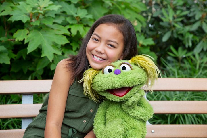 Salia Woodbury, 10, whose parents are in recovery from addiction, with "Sesame Street" character Karli.