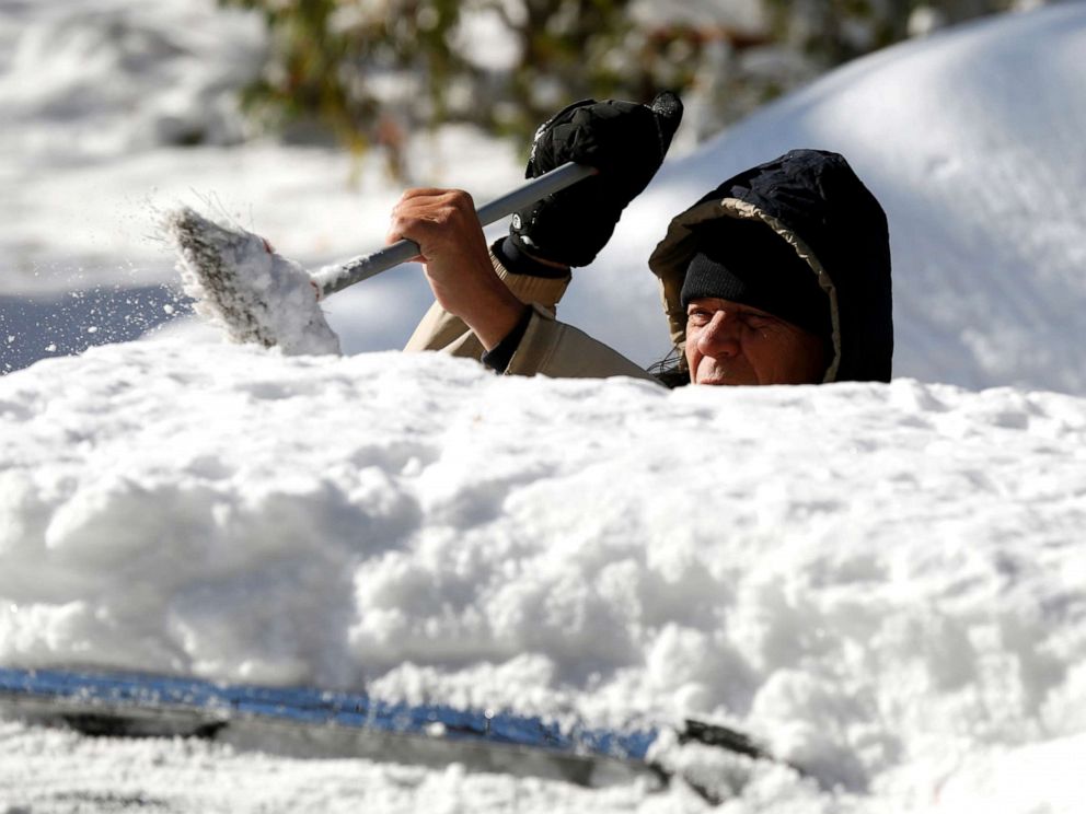 PHOTO: A man cleans the snow from the top of his vehicle in Detroit, Michigan, Nov. 12, 2019.