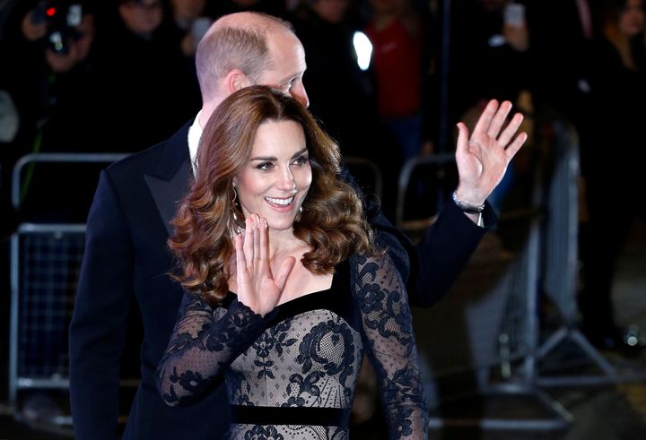 The royals are pictured waving to the crowds as they walked into the theater.