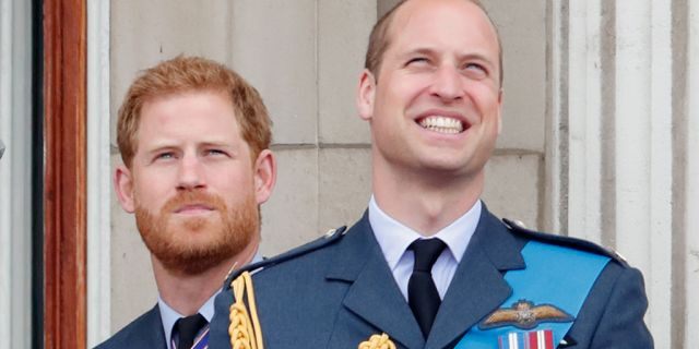 Prince Harry (left) and his older brother Prince William watch a flypast to mark the centenary of the Royal Air Force from the balcony of Buckingham Palace on July 10, 2018, in London, England.