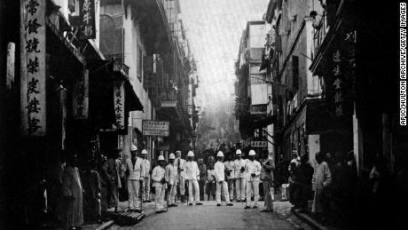 Plague inspectors on a street of Hong Kong, around 1890.