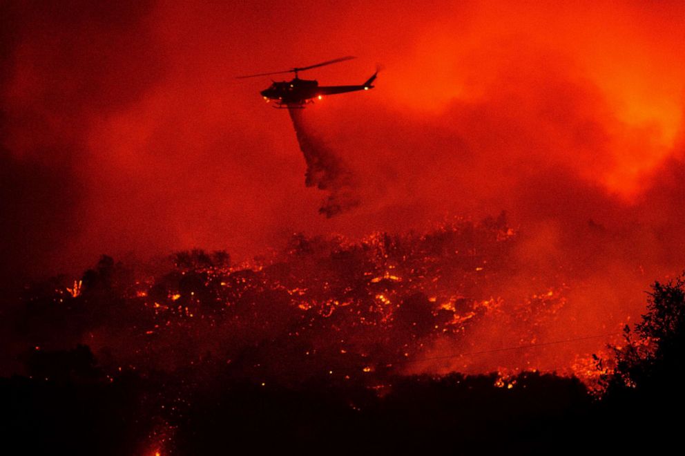 PHOTO: A helicopter drops water on the Cave Fire burning along Highway 154 in Los Padres National Forest, Calif., above Santa Barbara, Nov. 26, 2019.