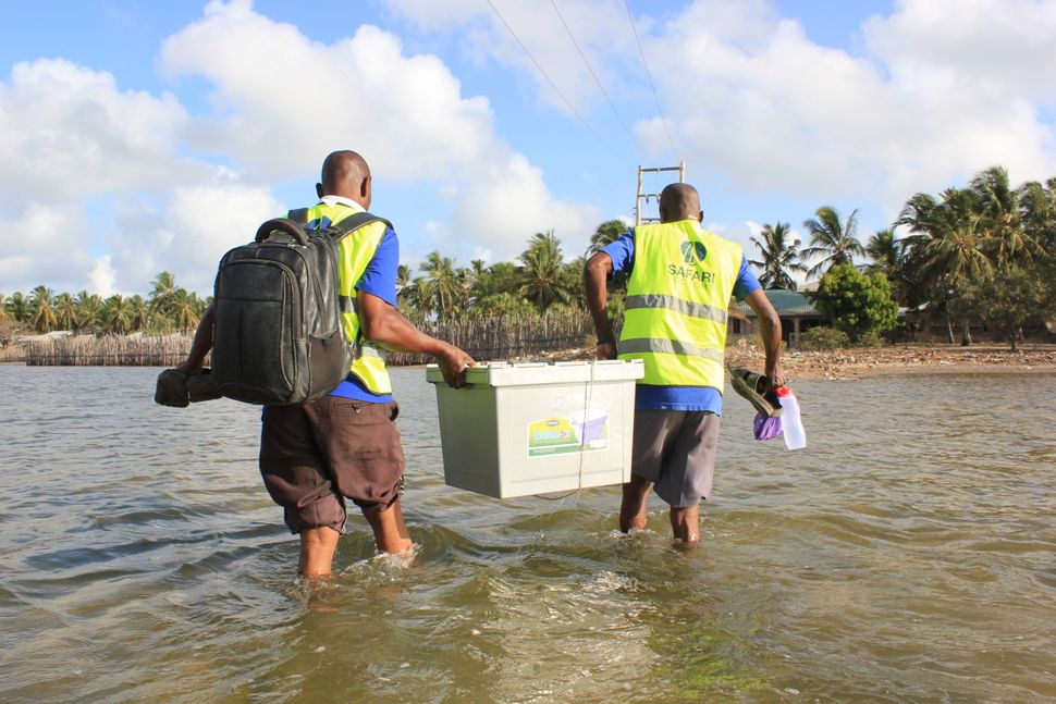 Safari Doctors carry supplies ashore at one of the stops on their route. The group sets up mobile clinics in each village for