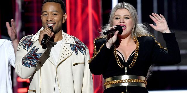 Recording artist John Legend (L) and host Kelly Clarkson speak onstage during the 2018 Billboard Music Awards at MGM Grand Garden Arena on May 20, 2018, in Las Vegas, Nevada.