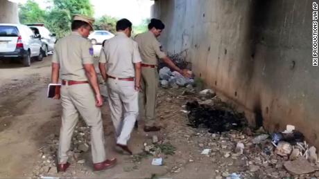 Indian police officers inspect the site where they found the burned body of a 27-year-old woman in an underpass on the outskirts of Hyderabad.