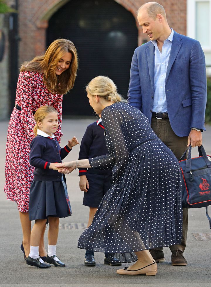 Helen Haslem, head of the lower school, greets Princess Charlotte as she arrives for her first day of school, with her brothe