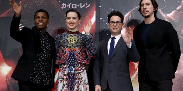 Director J.J. Abrams (2nd R), cast members John Boyega (L), Daisy Ridley (2nd L), and Adam Driver pose for pictures in Tokyo on December 11, 2015. 