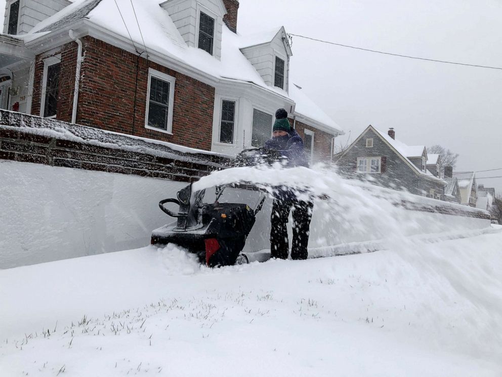PHOTO: Doreen Goy, of Warwick, R.I., uses a snowblower to clear a sidewalk after a second round of snow struck the area, Dec. 3, 2020. 