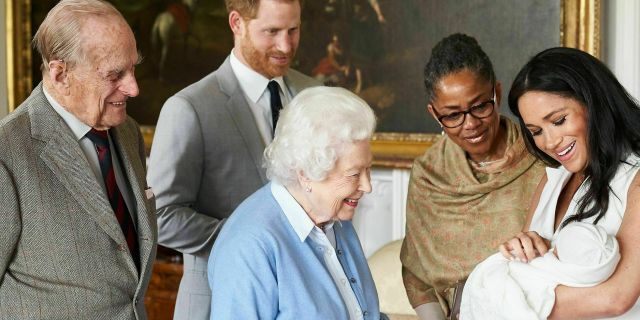 In this image made available by SussexRoyal on Wednesday, May 8, 2019, Britain's Prince Harry and Meghan, Duchess of Sussex, joined by her mother Doria Ragland, show their new son to Queen Elizabeth II and Prince Philip at Windsor Castle, Windsor, England.