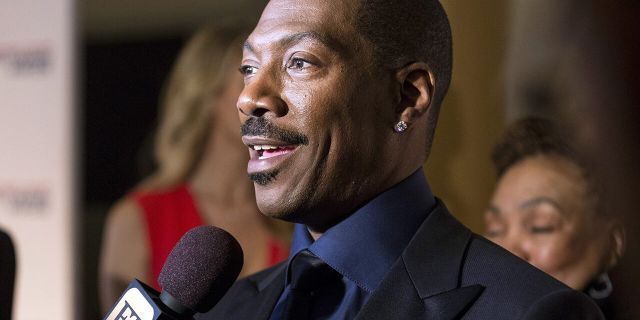 Eddie Murphy speaks to reporters as he arrives for the Mark Twain prize for Humor honoring Murphy at the Kennedy Center in Washington Oct. 18, 2015. 