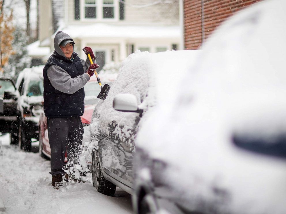 PHOTO: Benjamin Shoquette clears snow off his car outside his home, Dec. 3, 2019, in Providence, R.I. 
