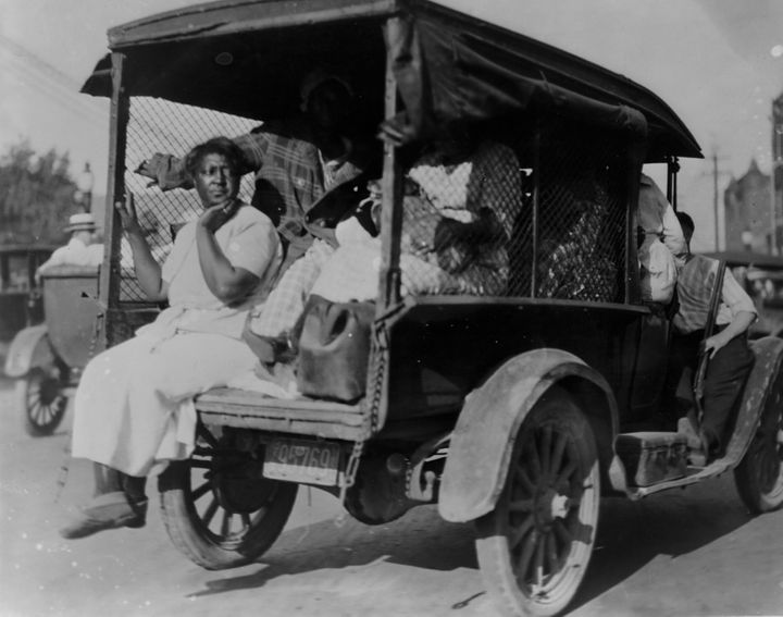 A woman seated on the back of a small truck loaded with people during the 1921 Tulsa race massacre.