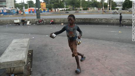 A boy flees from tear gas during clashes with Haitian police in Port-au-Prince on February 15, 2019.