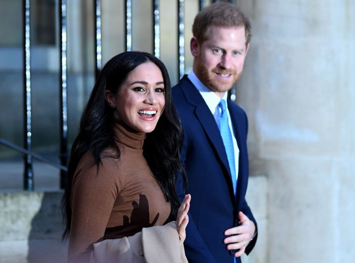 Britain's Prince Harry and his wife Meghan, Duchess of Sussex react as they leave after their visit to Canada House in London