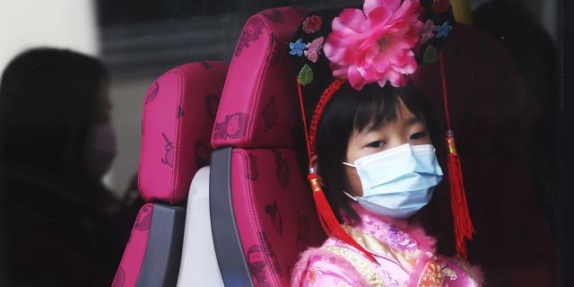 A girl wears a mask inside a bus in Hong Kong, Saturday, Jan. 25, 2020.
