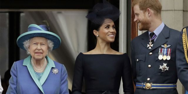 FILE - In this Tuesday, July 10, 2018 file photo Britain's Queen Elizabeth II, and Meghan the Duchess of Sussex and Prince Harry watch a flypast of Royal Air Force aircraft pass over Buckingham Palace in London. As part of a surprise announcement distancing themselves from the British royal family, Prince Harry and his wife Meghan declared they will “work to become financially independent” — a move that has not been clearly spelled out and could be fraught with obstacles. (AP Photo/Matt Dunham, File)