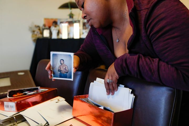 Ianna Burrell holds a photograph of her brother during his first year in prison as she pours over documents at her home, Frid