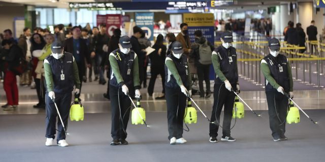 Workers spray antiseptic solution on the arrival lobby amid rising public concerns over the possible spread of a new coronavirus at Incheon International Airport in Incheon, South Korea, Tuesday, Jan. 21, 2020. Heightened precautions were being taken in China and elsewhere Tuesday as governments strove to control the outbreak of a novel coronavirus that threatens to grow during the Lunar New Year travel rush.