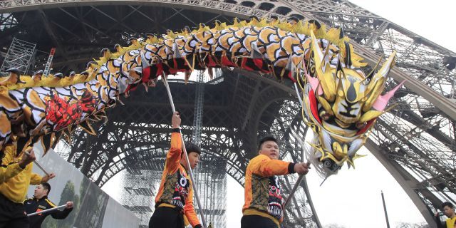 Members of the Chinese community dance with costumes to mark the Chinese New Year at the Eiffel Tower in Paris, Saturday Jan. 25, 2020.
