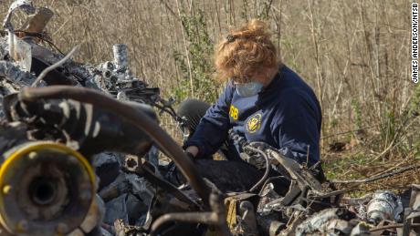 NTSB investigator Carol Horgan examines wreckage at the crash site as part of the NTSB&#39;s investigation.