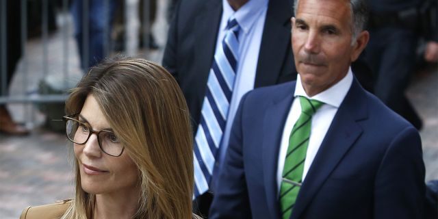 Actress Lori Loughlin, left, leaves as her husband Mossimo Giannulli, right, are accused of arranging a total collective payment of $500,000 to WIlliam Rick Singer to get their daughters recruited to USC as athletes on the crew team.