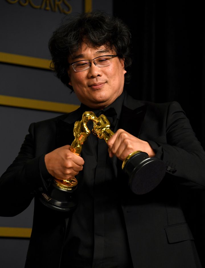 Bong Joon Ho makes his Oscar trophies kiss.