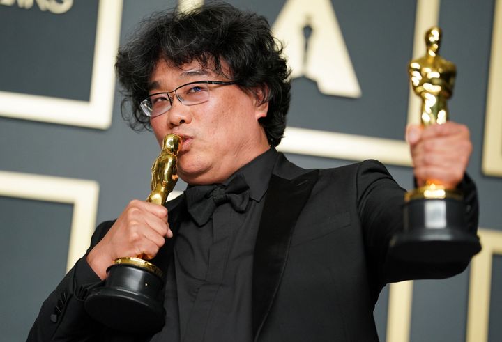 Bong Joon Ho kisses his Oscar trophies.