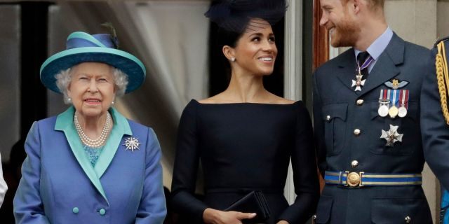 In this Tuesday, July 10, 2018 file photo Britain's Queen Elizabeth II, and Meghan the Duchess of Sussex and Prince Harry watch a flypast of Royal Air Force aircraft pass over Buckingham Palace in London. As part of a surprise announcement distancing themselves from the British royal family, Prince Harry and his wife Meghan declared they will “work to become financially independent” — a move that has not been clearly spelled out and could be fraught with obstacles.