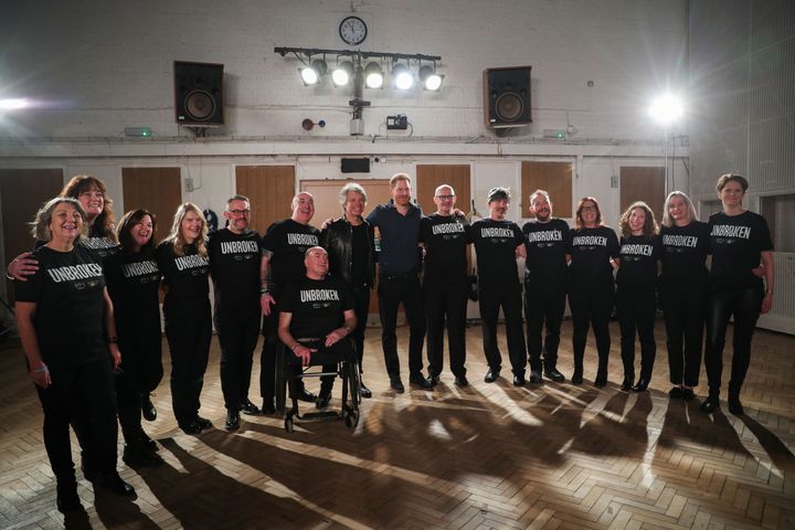 The two pose with members of the Invictus Games Choir.&nbsp;