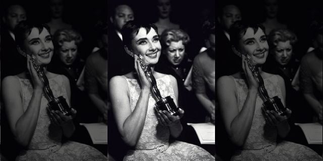 Actress Audrey Hepburn affectionately holding Oscar award she won for her performance in the movie 'Roman Holiday' at the Academy Awards ceremony in New York City.