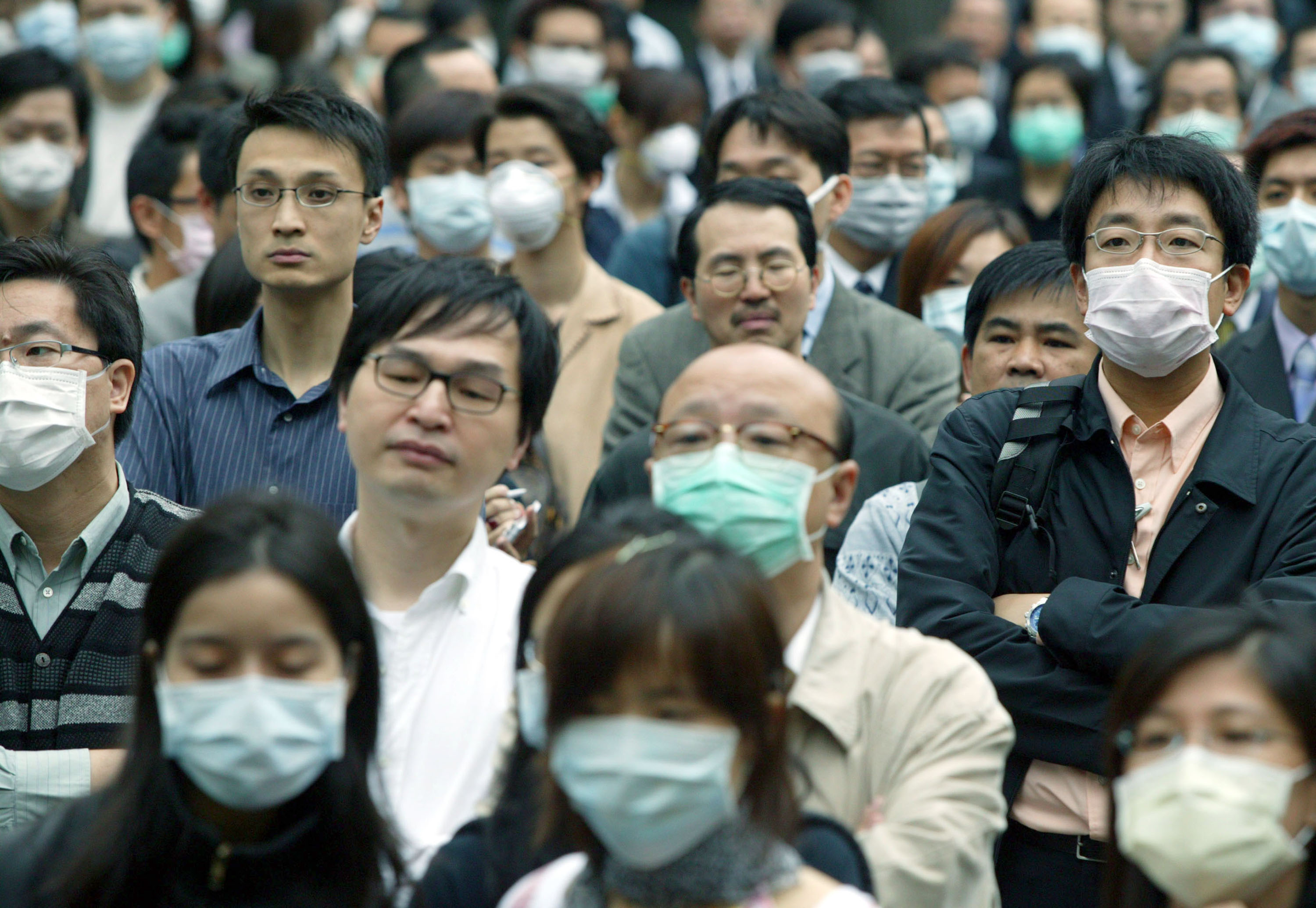 People wear masks to protect themselves against the Severe Acute Respiratory Syndrome (SARS) virus April 16, 2003 in Hong Kong. Christian Keenan/Getty Images