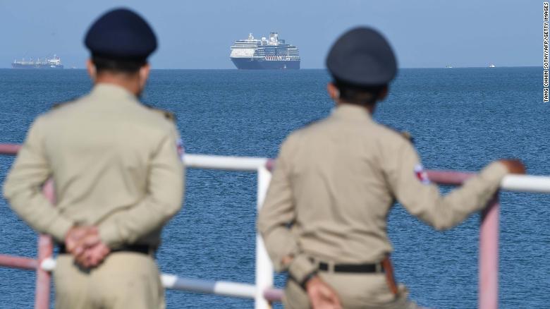 The Westerdam cruise ship is seen past Cambodian policemen as it approaches port in Sihanoukville, Cambodia's southern coast, on February 13.