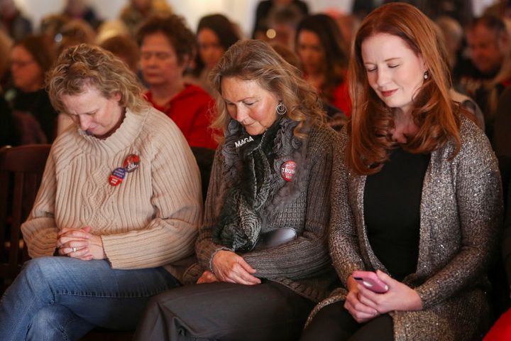 Supporters bow their heads in prayer at a Women for Trump bus tour stop in Sioux City, Iowa, on Jan. 16.