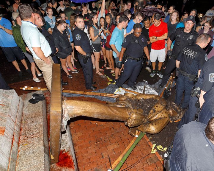 Police and protesters surround the toppled statue of a Confederate soldier known as Silent Sam on the University of North Car