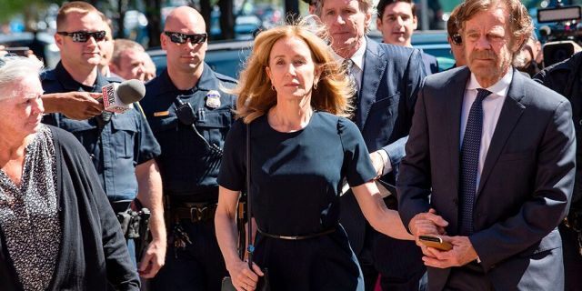 Actress Felicity Huffman, escorted by her husband William H. Macy, makes her way to the entrance of the John Joseph Moakley United States Courthouse September 13, 2019 in Boston, where she will be sentenced for her role in the College Admissions scandal.