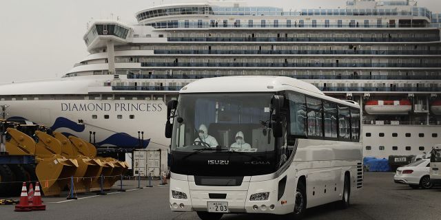 A bus leaves a port where the quarantined Diamond Princess cruise ship is docked Saturday, Feb. 15, 2020, in Yokohama, near Tokyo. A viral outbreak that began in China has infected more than 67,000 people globally. The World Health Organization has named the illness COVID-19, referring to its origin late last year and the coronavirus that causes it. (AP Photo/Jae C. Hong)