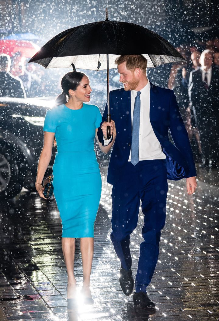 Meghan and Harry weather the rain together.