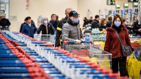 People wear masks while shopping at a supermarket in Milan, after Italy announced a sweeping quarantine zone covering its northern regions.