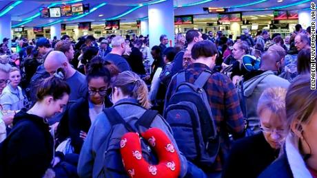 Travelers returning from Madrid wait in a coronavirus screening line at Chicago&#39;s O&#39;Hare International Airport on Saturday.