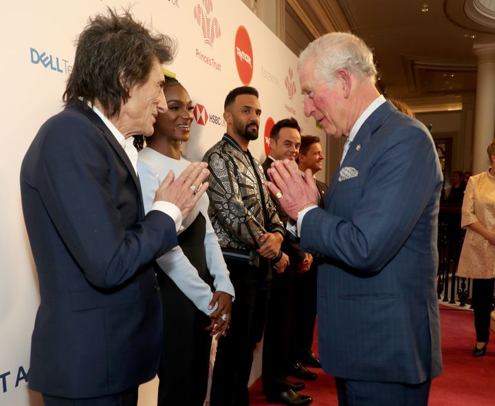 Charles uses a Namaste gesture to greet Rolling Stone Ronnie Wood as he attends the Prince's Trust and TK Maxx &amp; Homesens