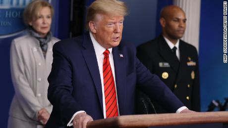 President Donald Trump speaks speaks on the latest developments of the coronavirus outbreak, while flanked by White House coronavirus response coordinator Debbie Birx, left, and US Surgeon General Jerome Adams, right, at the White House on Thursday.