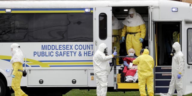 Residents from St. Joseph's Senior Home are helped onto buses in Woodbridge, N.J., Wednesday, March 25, 2020. More than 90 residents of the nursing home are being transferred to a facility in Whippany after 24 tested positive for COVID-19, according to a spokeswoman for CareOne.