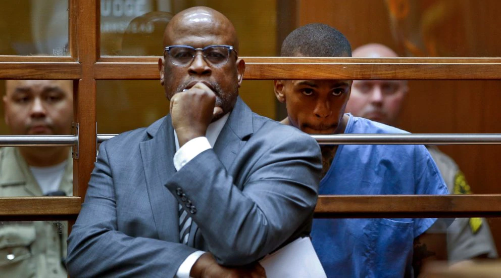 Eric Holder, the suspect in the killing of rapper Nipsey Hussle is seen with his attorney, Christopher Darden, front, in Los Angeles County Superior court Thursday, April 4, 2019. Hussle pleaded not guilty Thursday to murder and attempted murder charges. Holder was ordered held in lieu of $5 million bail. (AP Photo/Damian Dovarganes, Pool) thegrio.com