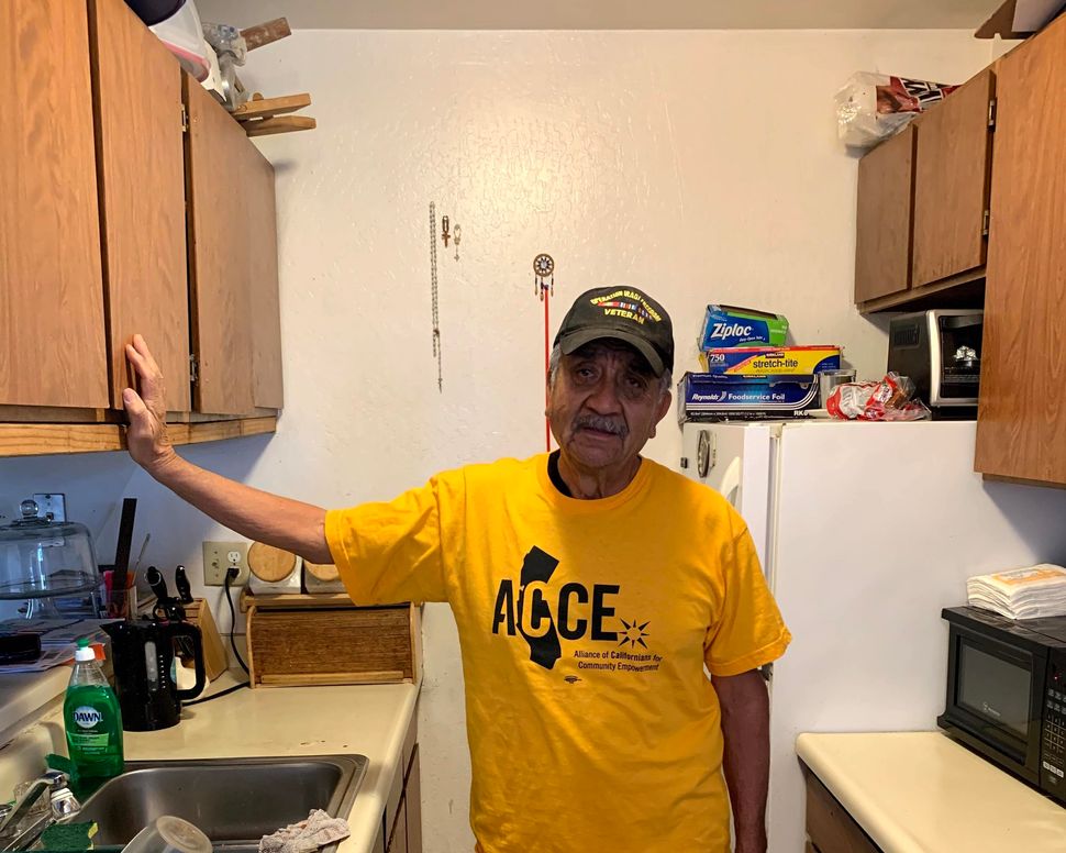 Francisco Perez stands in the kitchen of his Oakland apartment. He is on rent strike to protest the poor conditions of his ho