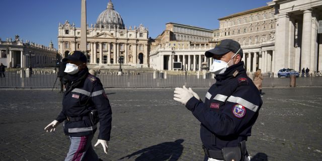 Police officers wearing masks patrol an empty St. Peter's Square at the Vatican, Wednesday, March 11, 2020. Pope Francis held his weekly general audience in the privacy of his library as the Vatican implemented Italy’s drastic coronavirus lockdown measures, barring the general public from St. Peter’s Square and taking precautions to limit the spread of infections in the tiny city state. (AP Photo/Andrew Medichini)