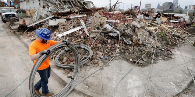 Electrical worker Tyler Morris rolls up damaged power cable Wednesday, March 4 near a store destroyed by a storm in Nashville, Tenn. 