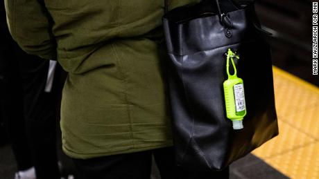 A hand sanitizer dispenser hangs from a subway rider&#39;s bag at the Times Square station in Manhattan. 